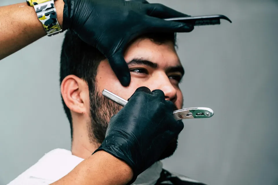 A beard being groomed with a razor